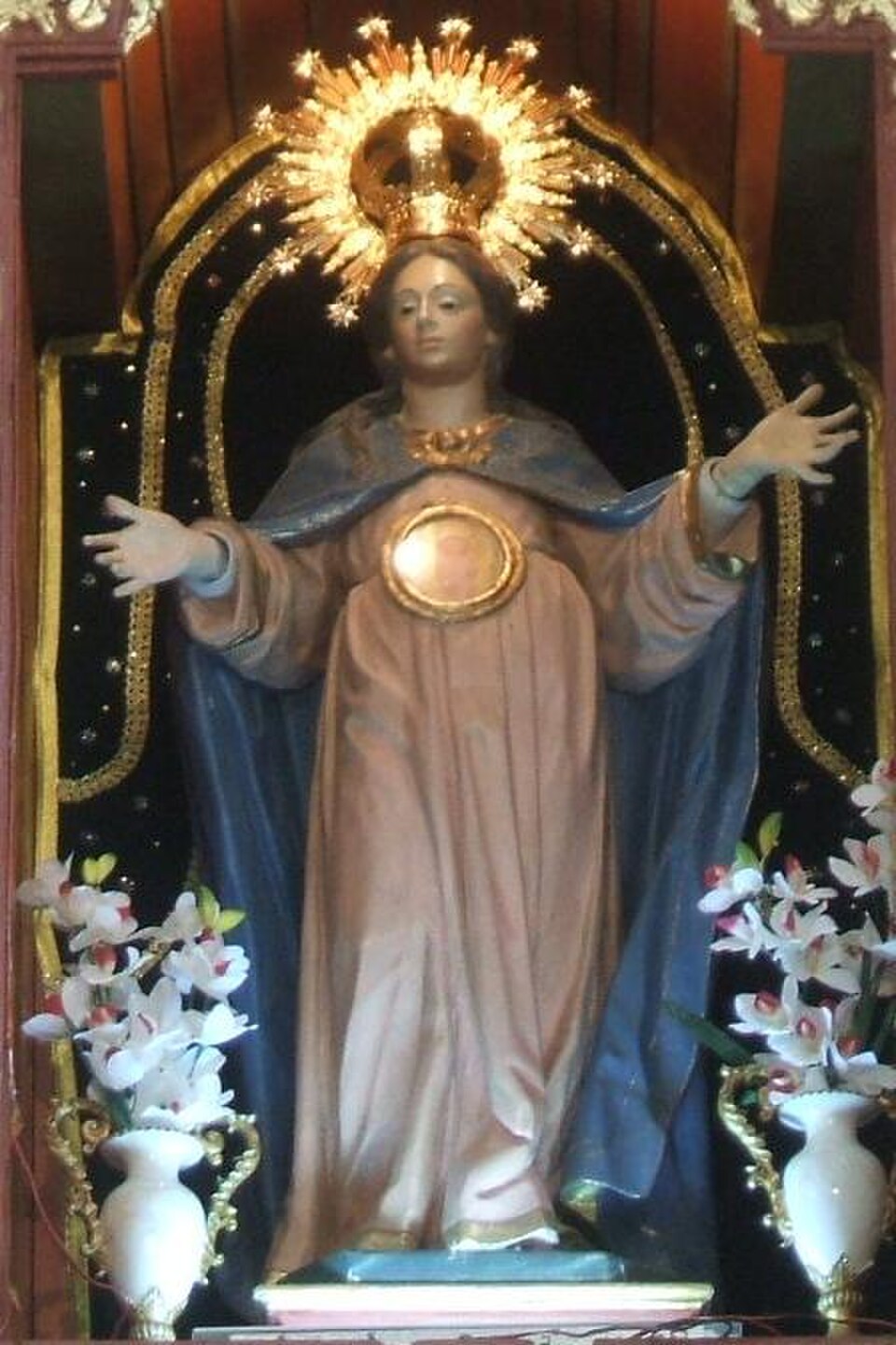 Talla de Nuestra Señora de la Esperanza con corona de rayos, manto azul, brazos abiertos y medallón en el vientre