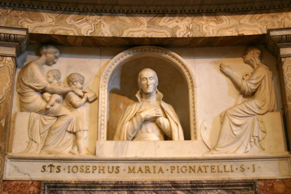 Busto de mármol de san José Pignatelli en una hornacina, con la mano en el pecho, entre relieves de figuras