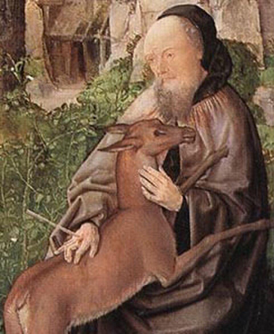 Pintura de san Egidio, anciano barbado con hábito pardo, acariciando una cierva en un paisaje boscoso