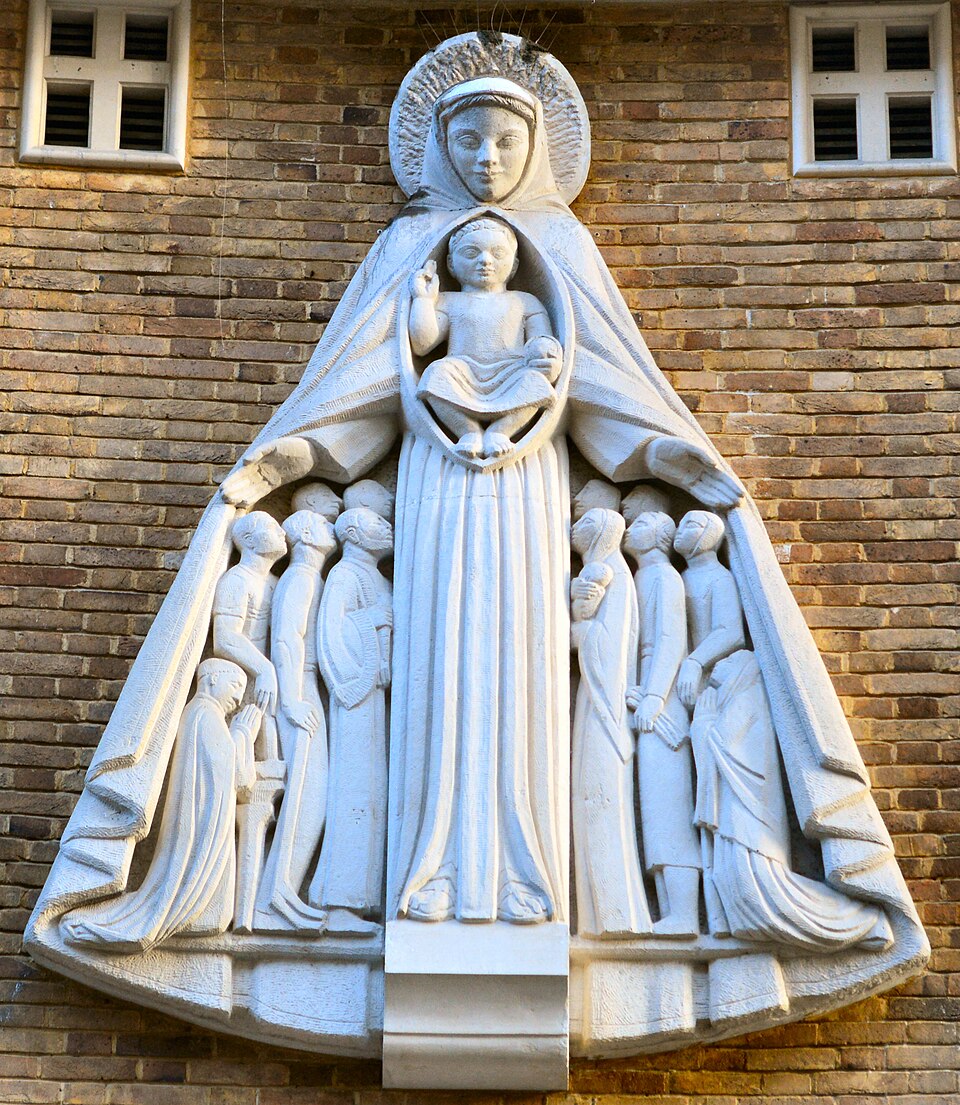 Relieve de piedra de Nuestra Señora de la Merced con el Niño, cobijando con su manto a varios fieles