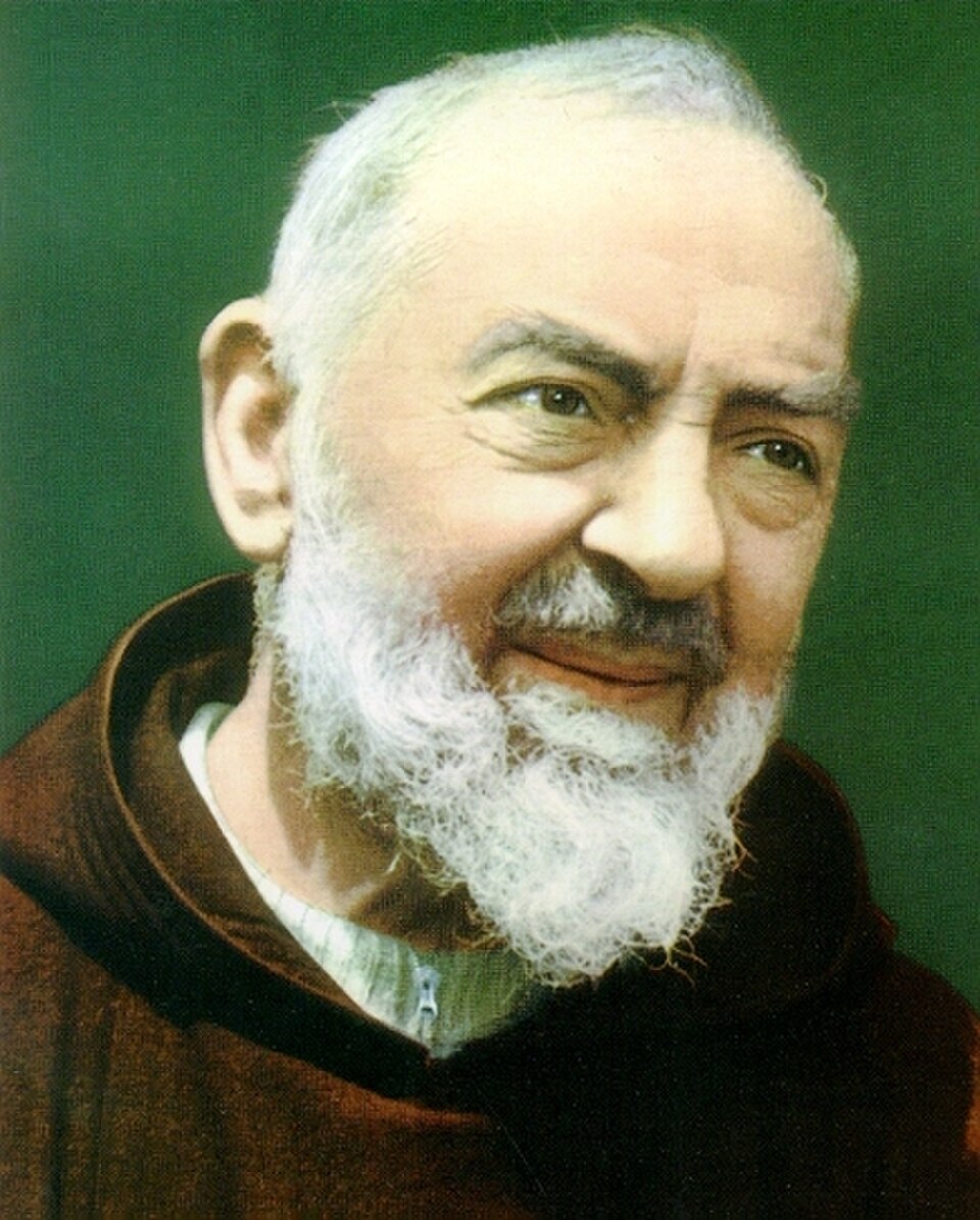 Retrato fotográfico en color de san Pío de Pietrelcina, con barba blanca y hábito capuchino marrón, sonriendo