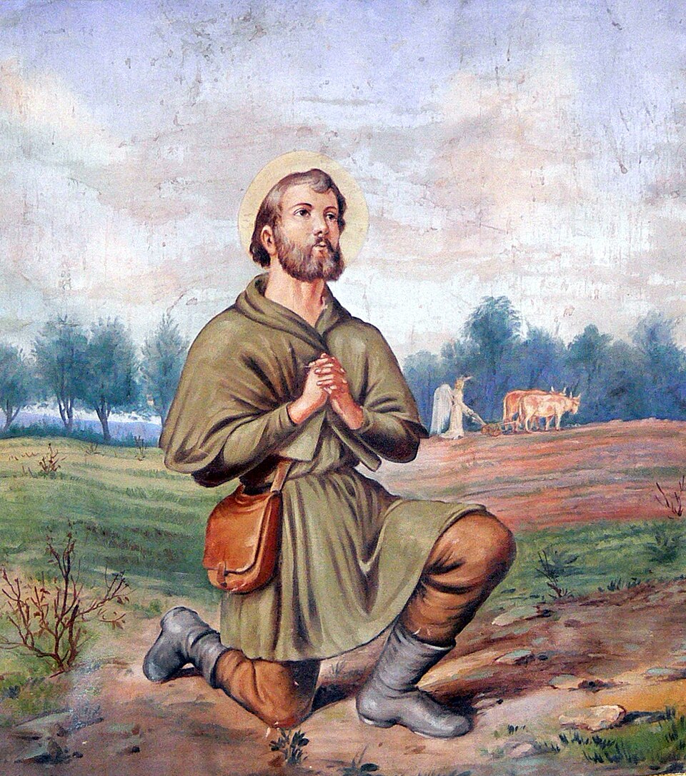 Pintura de san Isidro Labrador arrodillado en oración en el campo, con un ángel arando con bueyes al fondo