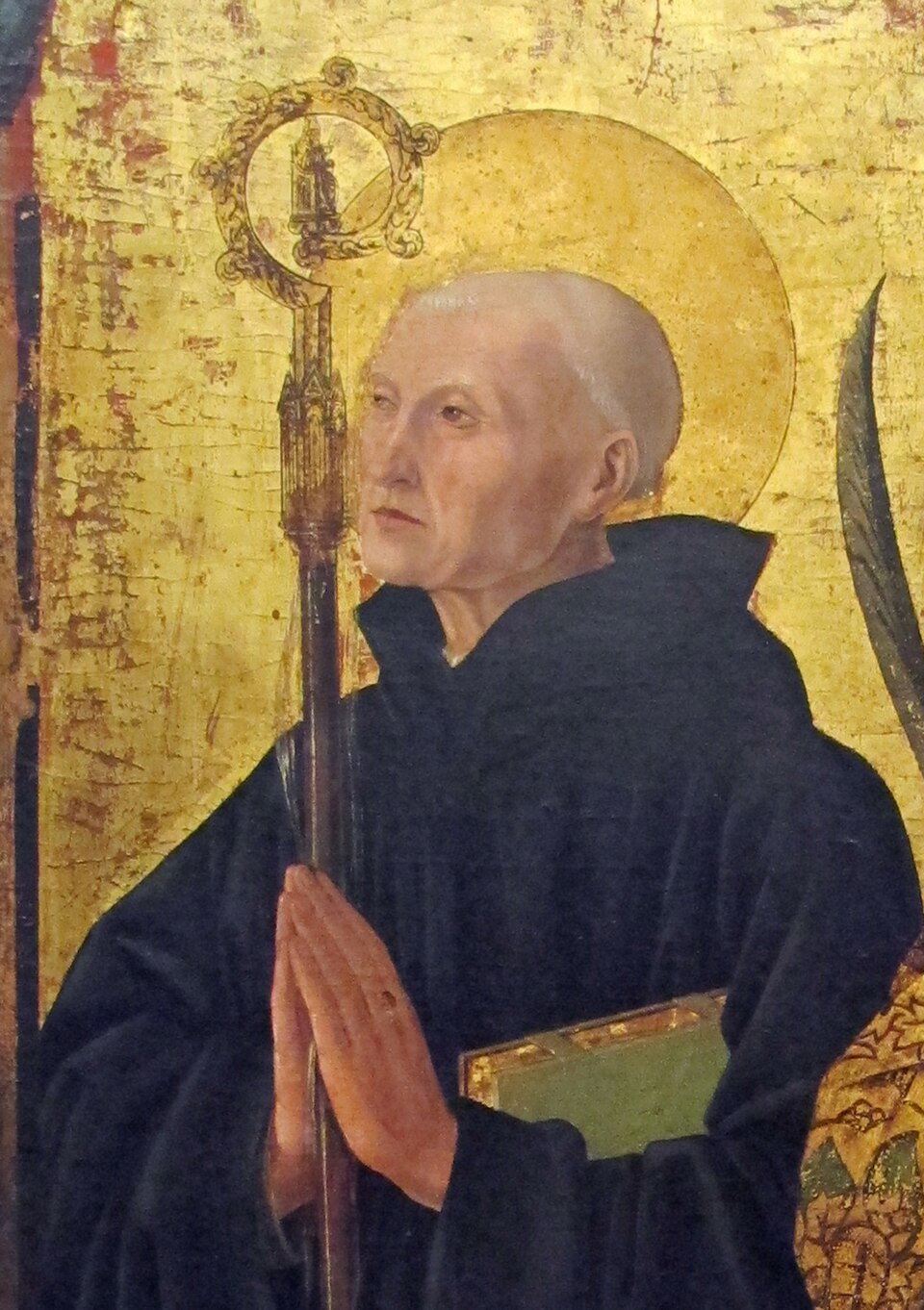 Pintura sobre fondo dorado de san Severino de Nórico con hábito negro, aureola y báculo, con las manos juntas