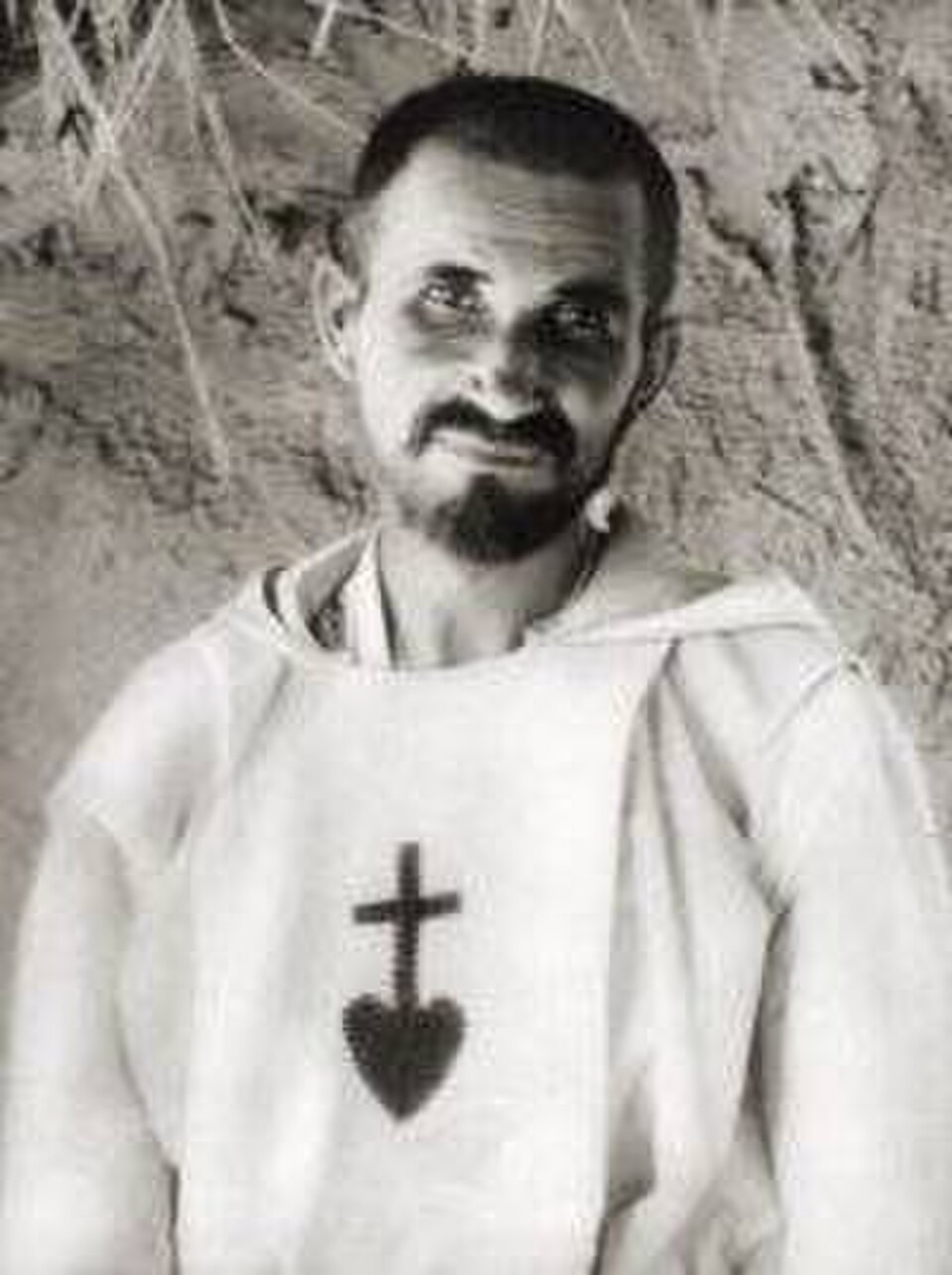Fotografía antigua de san Carlos de Foucauld con túnica blanca que lleva bordados un corazón y una cruz