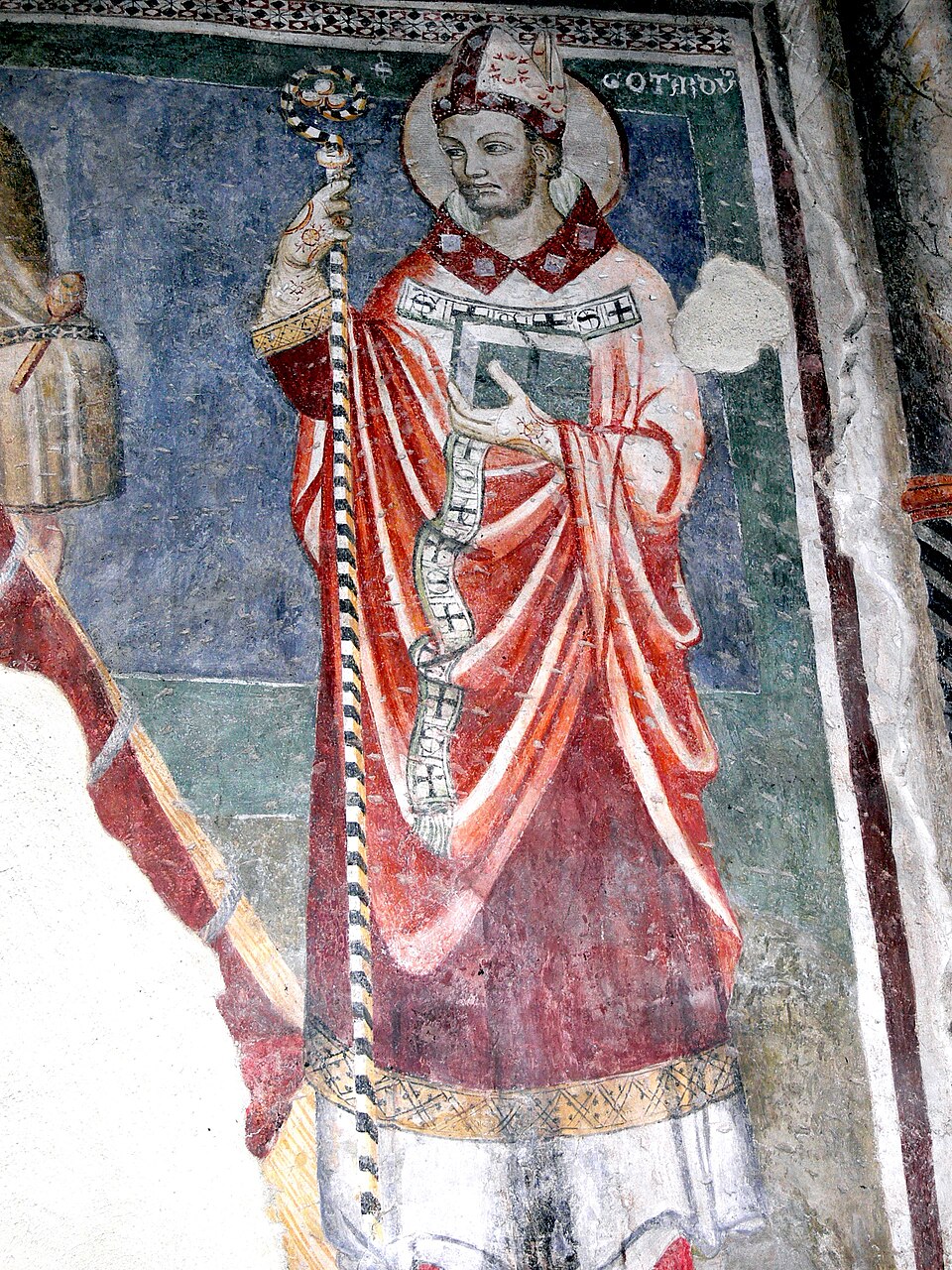 Fresco de san Godofredo de Hildesheim con mitra, aureola, casulla roja, báculo y un libro