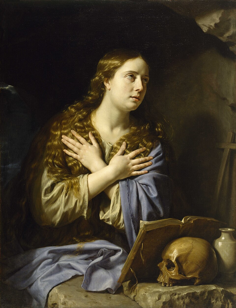 Pintura de santa María Magdalena llorando, con las manos cruzadas sobre el pecho, junto a un libro y una calavera