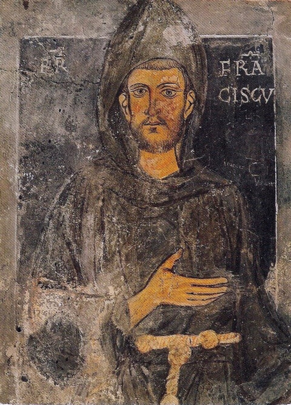 Fresco antiguo de san Francisco de Asís con hábito y capucha pardos, cordón y la mano en el pecho